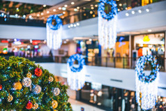 快乐x-mas关闭色彩斑斓的球礼物盒子和圣诞节问候图片包裹装饰绿色圣诞节树的购物购物中心背景装饰在圣诞节和新一年