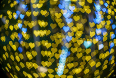 快乐x-mas黄色的色彩斑斓的光摘要心散景的光隧道圣诞节树背景装饰在圣诞节和爱新一年节日照明