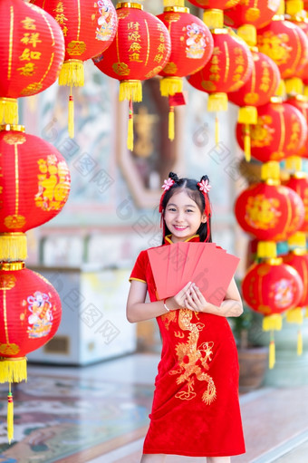 亚洲快乐小女孩穿红色的传统的<strong>中国</strong>人旗袍装饰持有红色的信封手和灯笼与的<strong>中国</strong>人文本祝福写《财富》杂志祝福为<strong>中国</strong>人