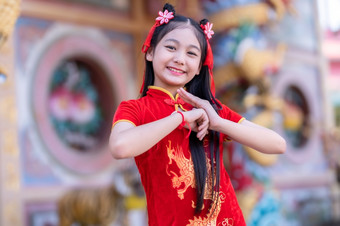 肖像微笑可爱的小亚洲女孩穿<strong>红色</strong>的旗袍衣服传统的装饰为中国人新一年节日庆祝<strong>文化</strong>中国中国人神社
