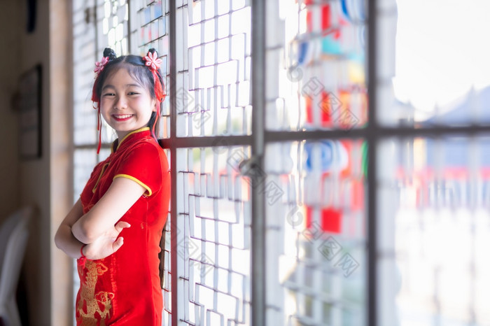 肖像微笑可爱的小亚洲女孩穿红色的旗袍衣服传统的装饰为中国人新一年节日庆祝文化中国中国人神社