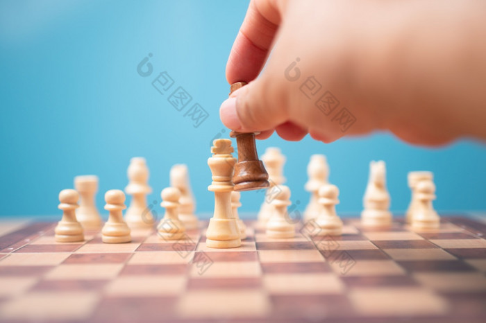 的手商人持有棕色（的）王国际象棋和使彻底失败竞争对手和赢得的游戏概念领导必须有业务策略和竞争对手评价竞争