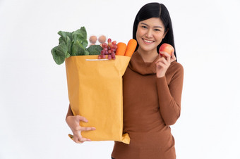 快乐亚洲女人微笑持有苹果和携带购物纸袋后的快递从的杂货店来了交付他的货物首页概念超市交付为新生活方式