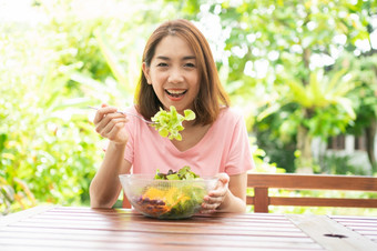 的快乐美丽的亚洲<strong>健康</strong>的中间岁的女人坐着的阳台的房子旁边的花园和吃<strong>健康</strong>的<strong>绿色</strong>沙拉概念<strong>健康</strong>哪和有营养的食物