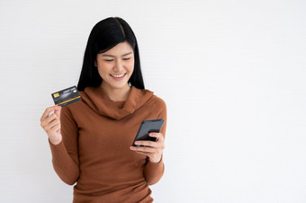 快乐亚洲女人持有卡信贷和智能手机为移动银行的互联网概念<strong>新生活</strong>方式和融资技术