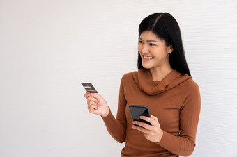 快乐亚洲女人持有卡信贷和智能手机为移动银行的互联网概念<strong>新生活</strong>方式和融资技术