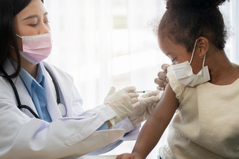 亚洲医生用户注射器针为注射接种疫苗非洲美国孩子们是被科维德接种疫苗为<strong>预防</strong>冠状病毒和<strong>流感</strong>概念免疫接种从接种