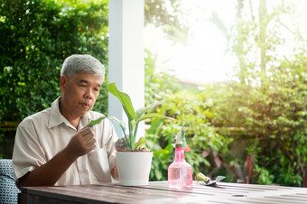 快乐和微笑亚洲老上了年纪的男人。种植为爱好后<strong>退休</strong>首页概念快乐生活方式和好健康为老年人