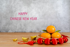 配件月球新一年中国人新一年假期概念假期背景橙色木篮子与黄金钱和红色的包白色李子开花棕色（的）灰色石头背景