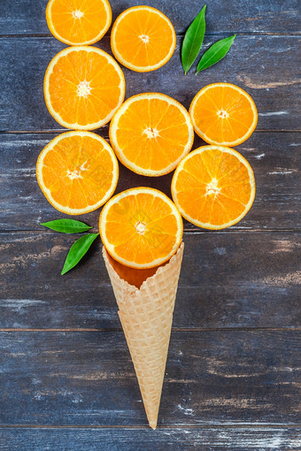 有<strong>创意</strong>的黑暗风格平躺前视图新鲜的橙色水果片冰奶油华夫格锥棕色（的）木<strong>表格</strong>背景与复制空间最小的夏天新鲜的柑橘类作文