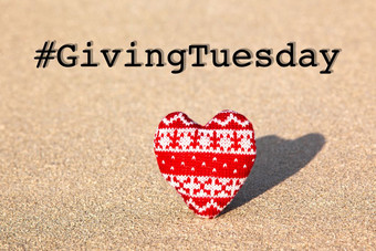 给周二全球一天慈善给后黑色的星期五购物一天慈善机构给帮助捐款和支持概念与文本消息标志和红色的针织心沙子海滩