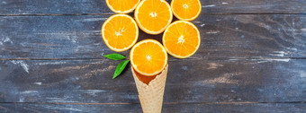 有<strong>创意</strong>的黑暗风格平躺前视图新鲜的橙色水果片冰奶油华夫格锥棕色（的）木<strong>表格</strong>背景与复制空间最小的夏天新鲜的柑橘类作文