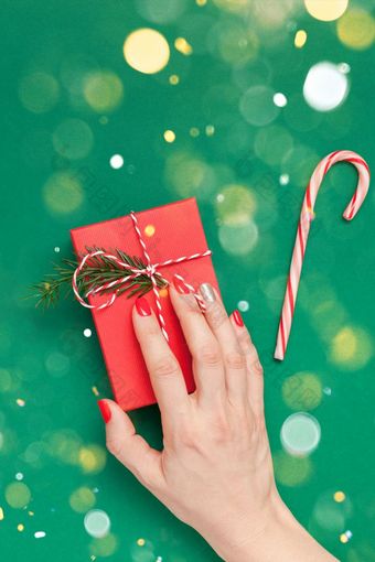 新一年圣诞节前视图圣诞节假期庆祝活动女人手红色的修指甲持有现在礼物盒子复制空间绿色颜色纸背景模板问候卡