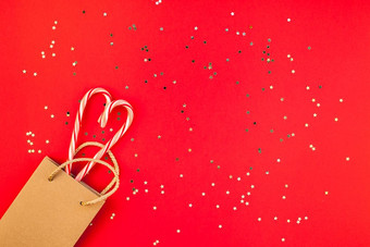 新一年圣诞节装饰平躺前视图圣诞节假期庆祝活动购物概念装饰糖果金星星闪闪发光的红色的纸背景模板框架为问候卡你的设计
