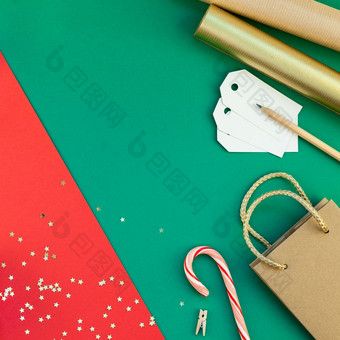 新一年圣诞节礼物准备Diy平躺前视图圣诞节假期庆祝活动手工制作的礼物盒子红色的绿色纸背景模板模型为问候卡你的文本设计