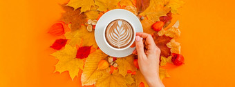秋天平躺作文与干叶子花环框架和咖啡拿铁杯女人手大胆的橙色颜色背景有创意的秋天感恩节秋天万圣节概念前视图复制空间