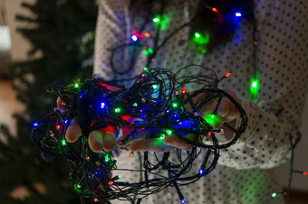 特写镜头女人rsquo手与红色的绿色和蓝色的彩色的灯<strong>装修</strong>的圣诞节树特写镜头女人rsquo手与彩色的灯<strong>装修</strong>的圣诞节树