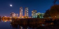 晚上视图现代建筑的奥博隆区基辅乌克兰查看从的南部部分纳塔卡公园的月亮照的布满星星的蓝色的天空的灯反映第聂伯河河