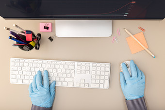 手与保护手套打字键盘电脑工人采取预防措施在的冠状病毒新冠病毒爆发前视图