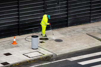 清洁工工人清洁街人行道上与高压力水飞机机多<strong>雨的</strong>一天复制空间