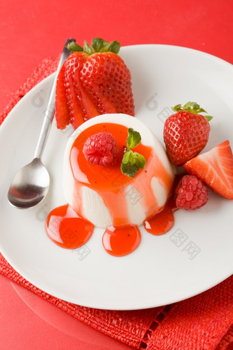照片意大利潘纳白色短衣甜点与草莓糖浆而且薄荷叶