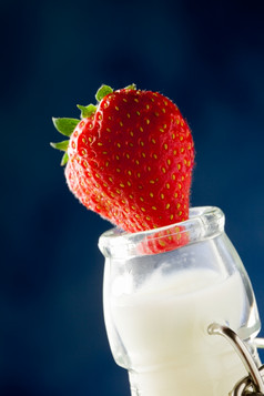 照片牛奶瓶与新鲜的红色的草莓