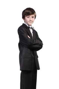 男孩黑色的西装白色衬衫而且弓领带孤立的白色背景