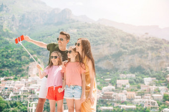家庭假期欧洲家庭<strong>四个</strong>采取自拍照片背景positano阿海岸父母和孩子们采取自拍照片背景positano小镇意大利阿海岸