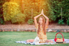 美丽的小女孩二分法瑜伽构成野餐的的公园小女孩瑜伽位置的公园
