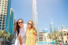 家庭妈妈和小孩子迪拜受欢迎的风景快乐家庭走迪拜与摩天大楼的背景