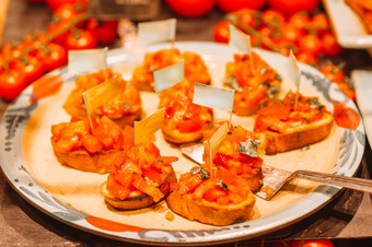 意大利意式烤面包片脆皮烤意大利ciabatta面包与樱桃西红柿罗勒和帕尔玛奶酪服务开胃菜美味的意大利意式烤面包片的木板