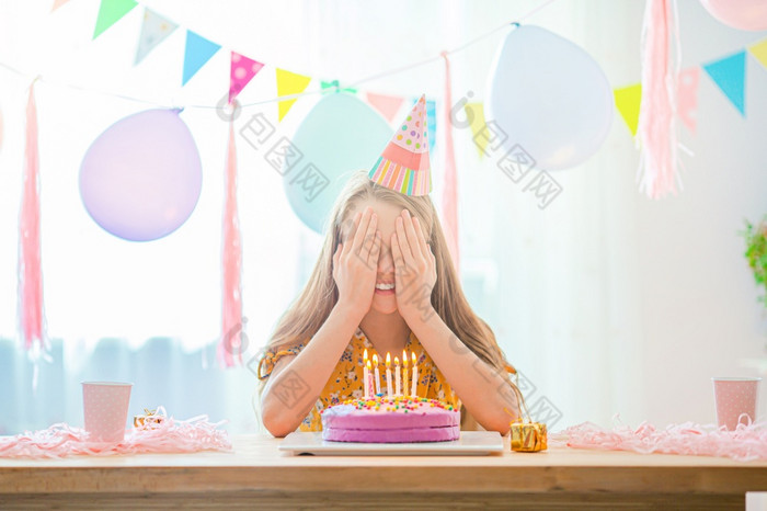 快乐小女孩使希望她的生日生日聚会，派对和祝愿概念高加索人女孩如痴如梦微笑和看生日彩虹蛋糕节日色彩斑斓的背景与气球生日聚会，派对和祝愿概念