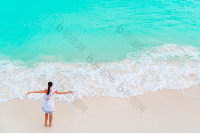 年轻的女人享受的太阳日光浴完美的绿松石海洋白色海滩年轻的女人享受的太阳日光浴完美的绿松石海洋