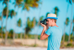 年轻的男人。拍摄相机热带海滩配置文件年轻的男人。拍摄美丽的海景白色沙子海滩