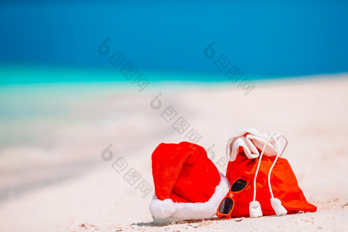 特写镜头红色的圣诞老人袋和圣诞老人老人他海滩圣诞节旅行假期和旅行cuprise概念海滩配件与圣诞老人他白色热带海滩配件与圣诞老人他白色热带海滩