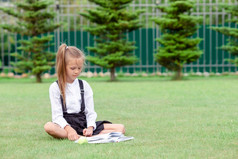 快乐小女学生在户外写作她的笔记本快乐小女学生与黑板户外