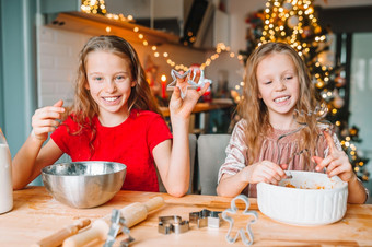 小女孩烹饪圣诞节姜饼烘焙和烹饪与孩子们为圣诞节首页小女孩使圣诞节姜饼房子壁炉装饰生活房间