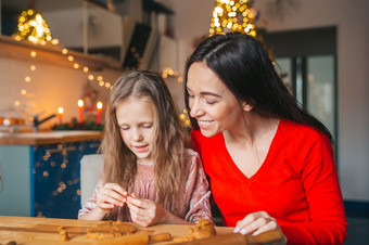 快乐妈妈。和小女孩烹饪圣诞节饼干厨房快乐家庭妈妈。和女儿烤饼干为圣诞节