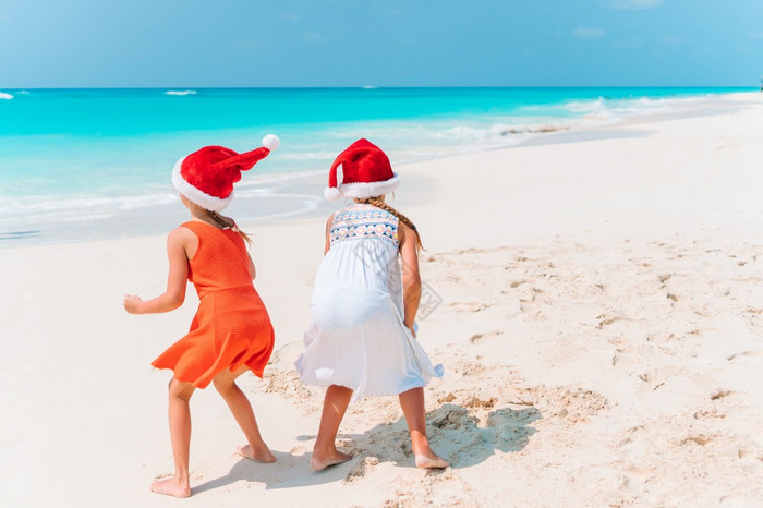 可爱的小女孩圣诞老人帽子与海星白色空海滩