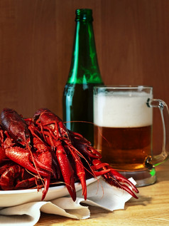 红色的煮熟的小龙虾和杯子啤酒