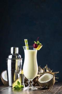 玻璃美味的冻皮娜可乐传统的加勒比鸡尾酒装饰片菠萝和樱桃服务黑暗木背景