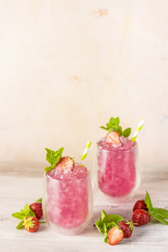 新鲜的草莓鸡尾酒新鲜的夏天鸡尾酒与草莓和冰多维数据集玻璃草莓苏打水喝光粉红色的背景