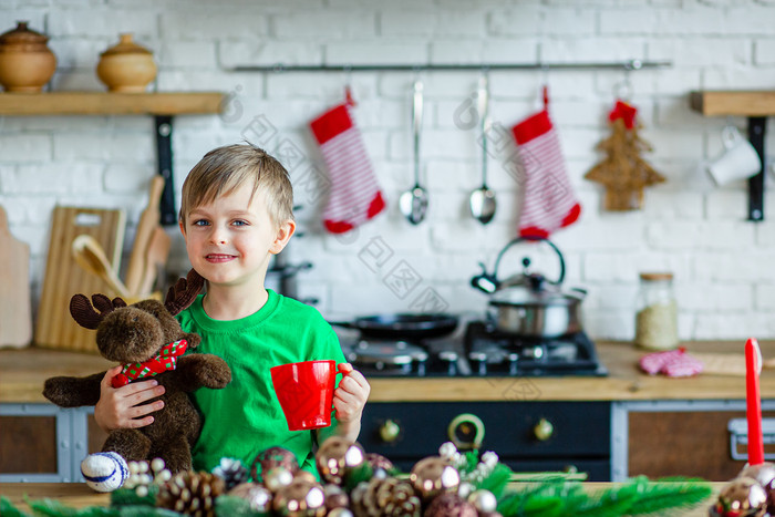 好早....小男孩饮料茶的厨房表格和拥抱泰迪驼鹿时间奇迹和实现欲望快乐圣诞节好早....小男孩饮料茶的厨房表格和拥抱泰迪驼鹿时间奇迹和实现欲望