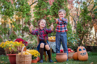 哥哥和妹妹玩的秋天花园包围水果蔬菜和水果庆祝的秋天收获哥哥和妹妹玩的秋天花园包围水果蔬菜和水果