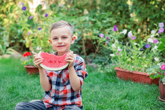 快乐孩子吃西瓜的花园孩子们吃水果在户外健康的零食为孩子们小男孩玩的花园咬片水瓜快乐男孩吃西瓜的花园孩子们吃水果在户外健康的零食为孩子们