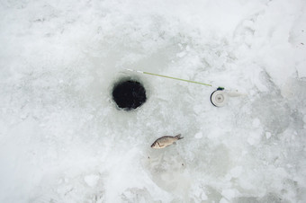 冰和钓鱼杆为冬天钓鱼冬天钓鱼小抓鱼冬天体育运动放松冰和钓鱼杆为冬天钓鱼冬天钓鱼小抓鱼