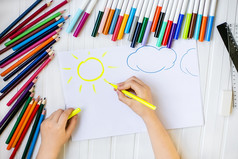 的孩子rsquo手是画与彩色的铅笔白色表纸木表格的孩子rsquo手是画与彩色的铅笔