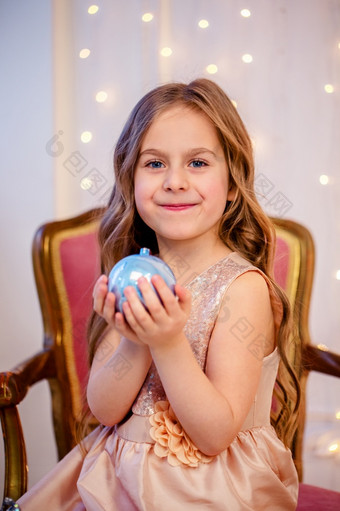肖像小女孩与卷曲的头发圣诞节夏娃的新一年将带礼物快乐的情绪期待惊喜肖像小女孩与卷曲的头发圣诞节夏娃的新一年将带礼物
