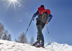 巡回演出滑雪攀爬山下阳光明媚的蓝色的天空