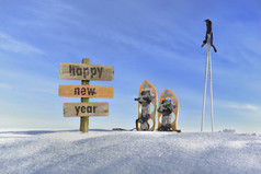 木标志与文本快乐新一年的雪下一个雪鞋和滑雪棒木标志与文本快乐新一年的雪nex雪鞋和滑雪坚持